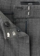 Pantalón de vestir estilo oxford de tiro medio, color gris oscuro con diseño de cuadros sutiles, corte recto amplio en las piernas y bolsillos laterales.