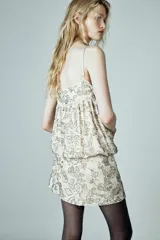 Vestido corto de tirantes finos ajustables con escote redondo. Presenta un diseño con abalorios bordados en toda la prenda y cierre lateral con cremallera oculta.