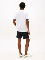 Remera blanca de manga corta Tommy Hilfiger, con cuello redondo y ribete azul en los puños. Presenta un pequeño logo bordado en el pecho.
