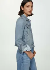 Chaqueta de denim celeste, con diseño corto, cuello de solapa, cierre frontal de botones metálicos, bolsillos frontales con solapa y bolsillos laterales ribeteados.