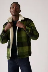 Campera de hombre con estampado a cuadros verdes y negros, forro de sherpa color crema y cuello de solapa. Cierre frontal con botones a presión.