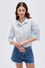 Camisa de algodón con estampado animal print en tonos marrones, de corte holgado, manga larga, cuello camisero y cierre frontal con botones.