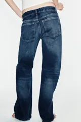 Jeans wide leg de tiro bajo y cinco bolsillos con efecto lavado y cierre frontal con cremallera y botón metálico.