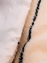 Acolchado de dos plazas color beige con rayas verticales negras.