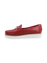 Mocasín de cuero color rojo con detalle de herraje metálico en el empeine y suela de plataforma dentada en color blanco.