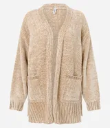 Cardigan abierto de punto chenille con textura aterciopelada, diseño alargado y bolsillos frontales. Presenta terminaciones acanaladas en puños y ruedo, con aberturas laterales para mayor comodidad.