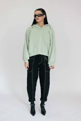 Pantalón negro de corte recto con costuras blancas contrastantes y detalle de cordones cruzados en la cintura.