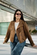Campera de gamuza color marrón, con diseño de doble botonadura, cuello alto con tira y hebilla ajustable, y bolsillos laterales.