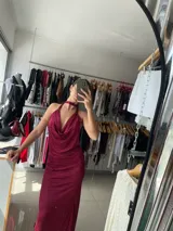 Vestido largo color borgoña con textura plisada, escote halter con cuello choker y espalda descubierta.