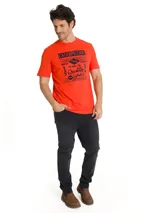 Remera roja de manga corta con cuello redondo y estampado vintage en el pecho con la inscripción "Caterpillar" y texto relacionado a la historia de la marca.