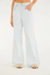 Pantalón de jean color celeste claro, de tiro medio con presillas para cinturón y cierre frontal con botón y cremallera. Presenta diseño de pernera amplia tipo wide leg, bolsillos delanteros clásicos y costuras decorativas a la altura de las rodillas.