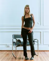 Pantalón negro de gabardina elastizada, corte bootcut, con puntilla en la cintura y lazos laterales.