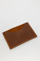 Tarjetero de cuero con diseño animal print en el frente y cuero liso marrón oscuro en la parte posterior, con compartimentos para tarjetas en ambos lados.