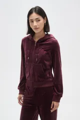 Campera con capucha de terciopelo color bordó, con cierre frontal, bolsillos tipo canguro y texto bordado en el pecho.