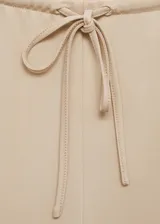 Pantalon wide leg de tiro alto, confeccionado en tejido fluido con cintura elástica y lazo ajustable.