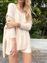 Sweater color crema de tejido de punto con cuello en V y mangas largas.