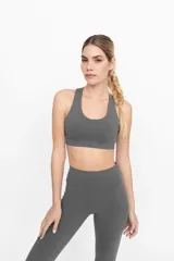 Top deportivo gris con espalda cruzada y compresión alta.