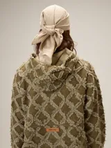 Chaqueta de algodón con diseño de textura desflecada en forma de rombos, cierre frontal con cremallera, cuello alto y puños elásticos.