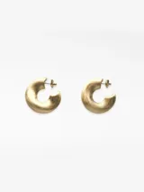 Par de aros tipo argolla de diseño irregular y orgánico, con acabado dorado mate. Cierre tipo broche.