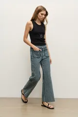 Pantalón de jean azul marino con diseño de rayas verticales blancas, tiro medio, corte acampanado y bolsillos delanteros aplicados.