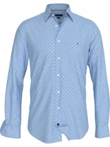 Camisa de manga larga para hombre, color celeste claro, con cuello con botones y puños abotonados. Presenta un microestampado repetitivo de cruces pequeñas en color azul oscuro.