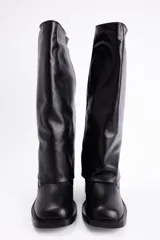 Bota de caña alta color negro, con diseño de solapa superior, taco cuadrado y punta redondeada.