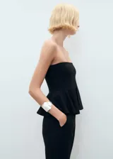 Top negro de corte peplum y escote palabra de honor, sin mangas.