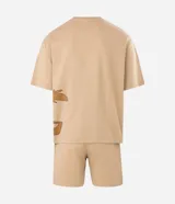 Pijama corto de algodón en color beige, compuesto por remera de manga corta con corte boxy y gran estampa frontal del Coyote de Looney Tunes, y bermuda haciendo juego con estampado lateral.