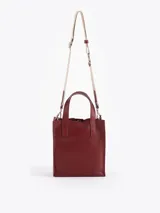 Cartera tipo tote pequeña de cuero color tostado, con doble asa superior y herrajes metálicos plateados en forma de llama en la base de las manijas. Presenta el logo de la marca estampado en la parte inferior frontal.