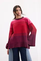 Sweater de tejido de punto con diseño degradé en tonos rojo, rosado y bordó, cuello redondo y mangas amplias.