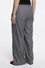 Pantalón palazzo de tiro alto con estampado a rayas verticales rosas y blancas, con cintura elástica ajustable con cordón.