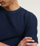 Remera masculina de manga corta, cuello redondo y color marrón oscuro, confeccionada en tejido acanalado de poliéster y algodón.