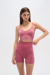 Top color rosa con breteles finos, corte al cuerpo, con elástico en la base y escote profundo.