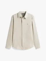 Camisa de manga larga Tommy Hilfiger de corte slim, confeccionada en tejido de piqué Oxford con tecnología de regulación de temperatura. Presenta cuello inglés, cierre frontal con botones y el logo de la marca bordado en el pecho.