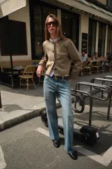 Chaqueta color tostado con efecto ante, cuello redondo y manga larga. Presenta detalles de acabados trenzados en el cuello, el cierre frontal, los puños y el bajo. Cuenta con cierre frontal de botones y bolsillos delanteros de vivo.