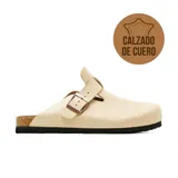 Zueco casual de cuero color beige de la marca Marco Donatti, con diseño cerrado en la parte delantera, tira ajustable con hebilla metálica y suela de corcho y goma.
