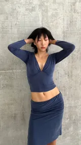 Top de manga larga confeccionado en lycra, con escote en V profundo y diseño ajustado al cuerpo.