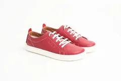 Zapatillas de cuero blanco con diseño minimalista, cordones al tono y suela de goma color suela con costura vista.