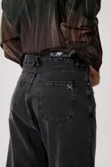 Jean baggy de tiro medio en denim claro, con estructura relajada y pierna ancha. Presenta costuras visibles y diseño clásico de cinco bolsillos.