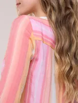 Blusa de gasa Zac & Rachel con estampado de rayas verticales en tonos rosados, amarillos y blancos. Presenta escote en V con cuello mao, cierre frontal con botones, un bolsillo aplicado en el pecho, mangas largas con presilla para regular el largo y detalle de nudo en el dobladillo inferior.