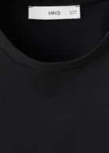 Camiseta negra de algodón con cuello redondo, mangas cortas y detalle de encaje en el borde inferior.