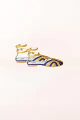 Sandalias tipo cangrejeras con rejilla en la punta y laterales combinados en ante morado y glitter dorado. Ajuste con hebilla en el tobillo. Fabricadas en España con interior de piel y suela de cuero. Cuentan con una cuña interna de 1,5 cm.