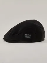 Boina de estilo clásico color negro, confeccionada en tejido de punto acanalado. Presenta una etiqueta rectangular con el logo de la marca Benson & Thomas en el lateral.