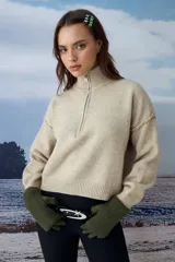 Sweater tejido de punto color beige, con cuello alto y cierre frontal parcial. Presenta mangas largas con costuras caídas y puños y ruedo acanalados.