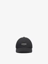 Gorra de visera corta Jacquemus modelo La Casquette Gadjo, color negro, con logotipo metálico plateado en la parte frontal.