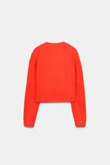 Jersey de punto de cuello redondo y manga larga, con acabado en rib en puños y ruedo.