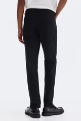 Pantalón de sarga de algodón con corte slim fit, cierre de cremallera y botón, diseño clásico de cinco bolsillos.