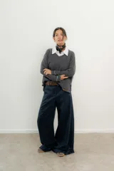 Pantalón de tiro medio-alto con piernas anchas y corte holgado. Presenta un diseño con pasacintos en la parte trasera en contratono y detalle de ojalillo en el bolsillo posterior.