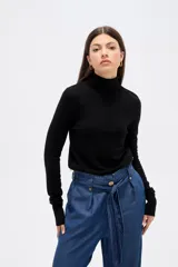 Polera de lyocell color negro, con cuello alto y ajuste al cuerpo, de manga larga.