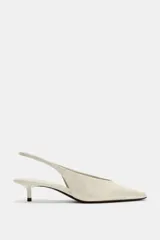 Zapato destalonado de piel en color blanco roto, con tacón kitten fino, puntera fina y tira elástica trasera.